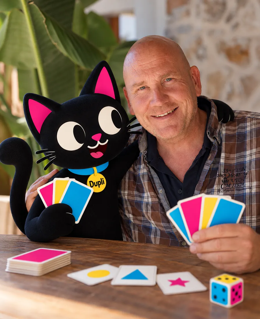 Ralf Zur Linde at a table with Dupli, both holding cards
